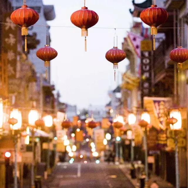 Vista ravvicinata di una serie di lanterne rosse appese sopra una strada a Chinatown. San Francisco, California.